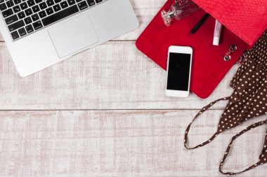 Moda kadın aksesuarları. Lüks el yapımı yılan derisi (piton) çanta, kozmetik, makyaj aksesuarları moda seti, dizüstü bilgisayar, akıllı telefon. Üst görünüm, düz yatıyordu, açık ahşap arka plan. Metin için boş/boş alan.