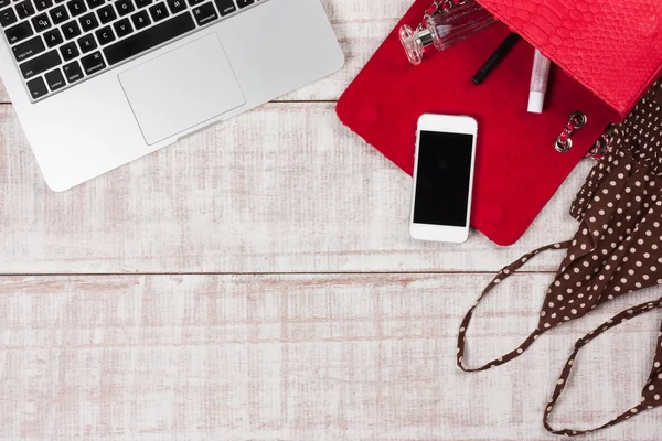 Moda kadın aksesuarları. Lüks el yapımı yılan derisi (piton) çanta, kozmetik, makyaj aksesuarları moda seti, dizüstü bilgisayar, akıllı telefon. Üst görünüm, düz yatıyordu, açık ahşap arka plan. Metin için boş/boş alan.