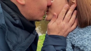 Güzel genç bir çift öpüşüyor, yakın çekim, sonbahar zamanı. Yavaş çekim videosu.