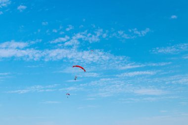 Paraşütçü gökyüzünde uçuyor, güneşli karşıtlık görüntüsü.