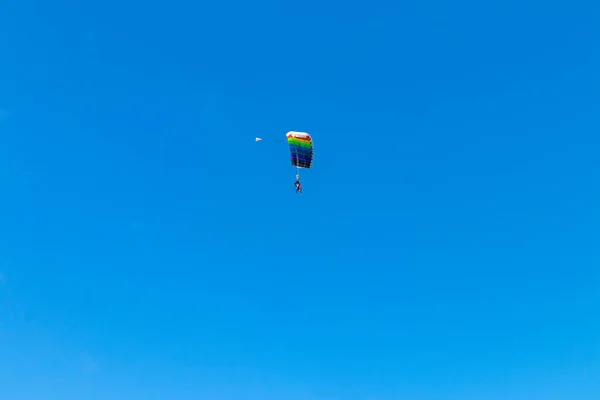 Fallschirmspringer fliegt in den Himmel, sonniges Kontrastbild. — Stockfoto