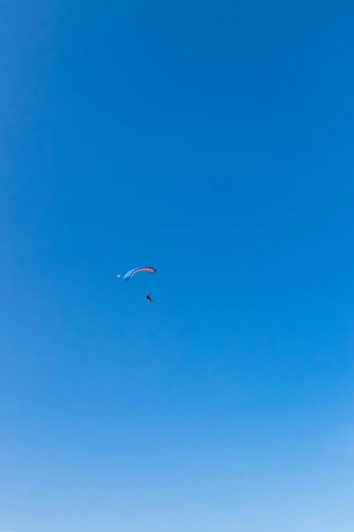Fallskärmshoppare flyger på himlen, solig kontrast bild. — Stockfoto