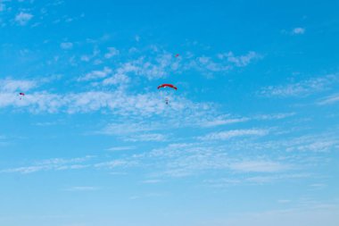 Paraşütçü gökyüzünde uçuyor, güneşli karşıtlık görüntüsü.