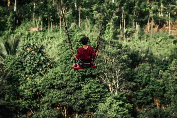 Joven balanceándose en la selva tropical de la isla de Bali, Indonesia. Balancéate en los trópicos. Cambios - tendencia de la isla de Bali. — Foto de Stock