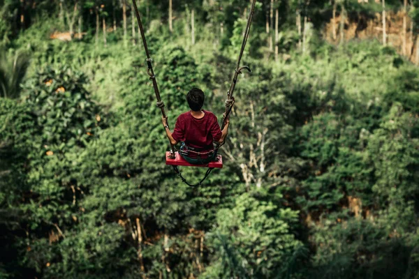 Joven balanceándose en la selva tropical de la isla de Bali, Indonesia. Balancéate en los trópicos. Cambios - tendencia de la isla de Bali. — Foto de Stock