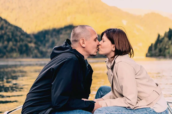 Молода пара цілується і обіймається біля озера в горах . — стокове фото