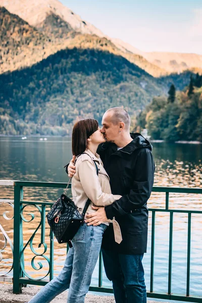 Giovane coppia baciare e abbracciare vicino al lago in montagna. — Foto Stock