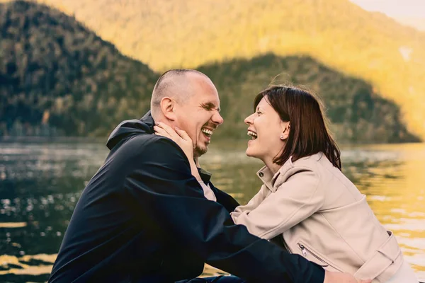 Молода пара цілується і обіймається біля озера в горах . — стокове фото