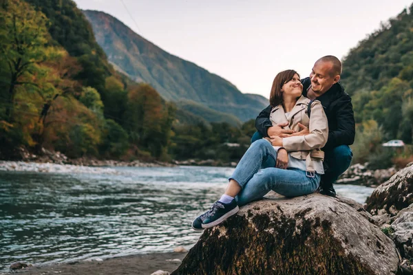 Giovane coppia baciare e abbracciare vicino al lago in montagna. — Foto Stock