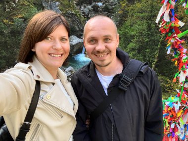 Mutlu çift sonbahar tatilinde şelalede selfie portresi çekiyor..