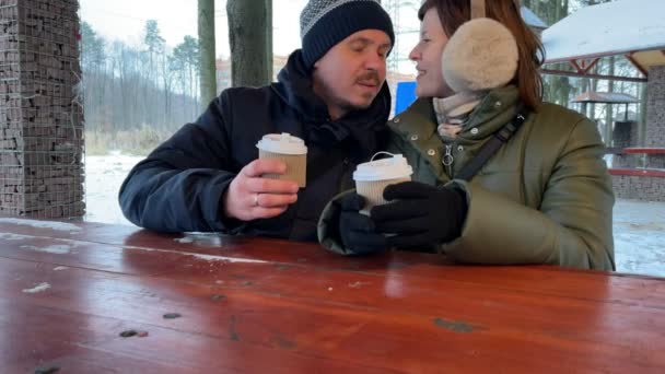 Jeune couple boit du café ensemble en plein air à l'hiver. Couple romantique. Mouvement lent. — Video