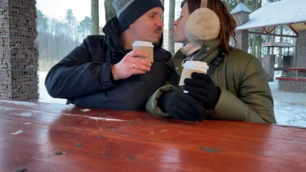 Jeune couple boit du café ensemble en plein air à l'hiver. Couple romantique. Mouvement lent. — Video