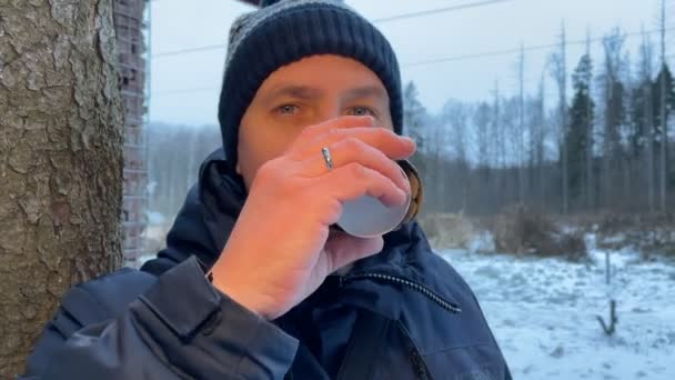 Молодой мужчина с чашкой кофе в зимнее время. — стоковое видео
