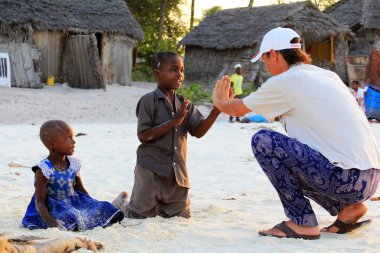 Yetişkin adam turist Afrika çocuklarla oynuyor