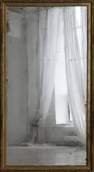 Réflexion d'une fenêtre avec rideaux dans un vieux miroir — Photo