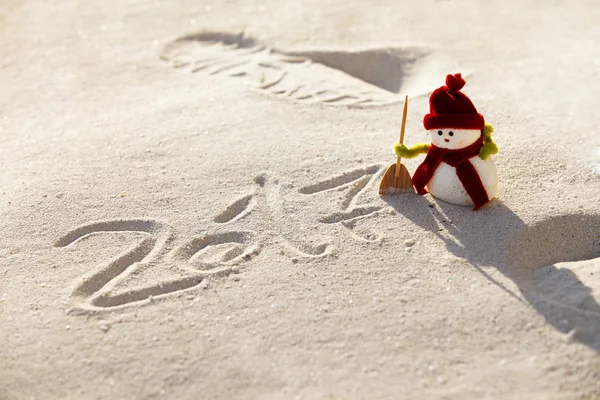 Игрушечный снеговик на песке — стоковое фото