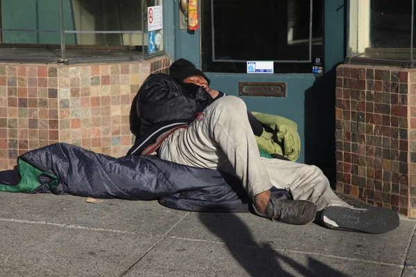 Evsiz bir adam sokakta yatıyor. — Stok fotoğraf