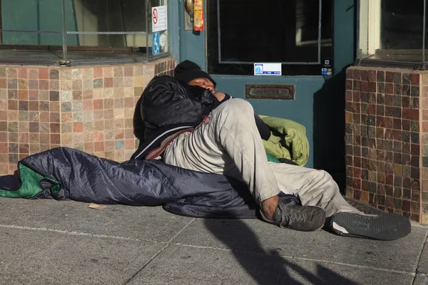 Homem sem-teto dorme na rua — Fotografia de Stock