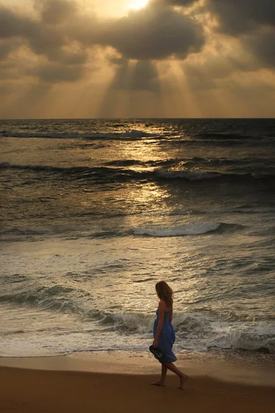 Fille sur une plage au coucher du soleil — Photo