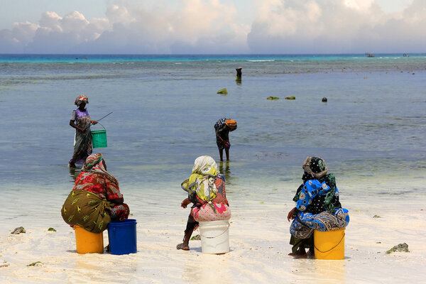 African women in traditional dress on the beach