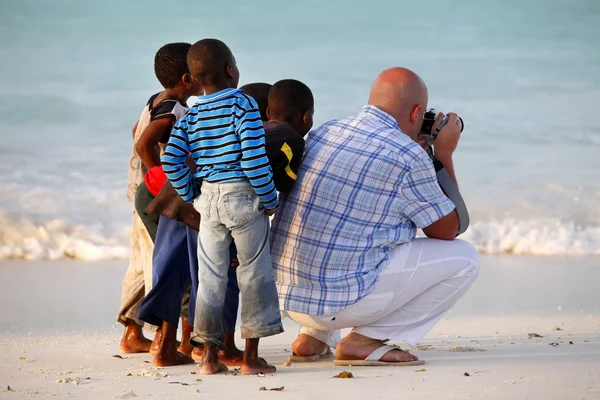 Белый мужчина с африканскими детьми — стоковое фото