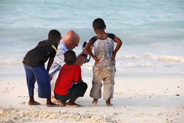 Uomo bianco con bambini africani — Foto Stock