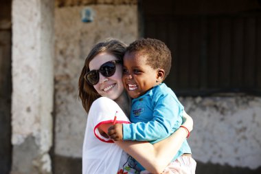 Genç kadın - bir turist küçük Afrikalı kız ile