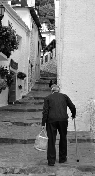 Elderly man climbs the stairs of a street in a town — Stock Photo, Image