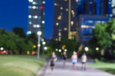 Şehir parkındaki bokeh arka planında soyut bulanık insanlar egzersizi.