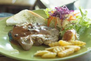 Izgara domuz pirzolası cips ve sebze ile.