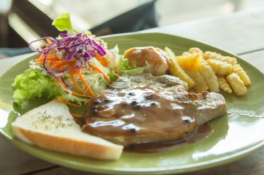 Izgara domuz pirzolası cips ve sebze ile.