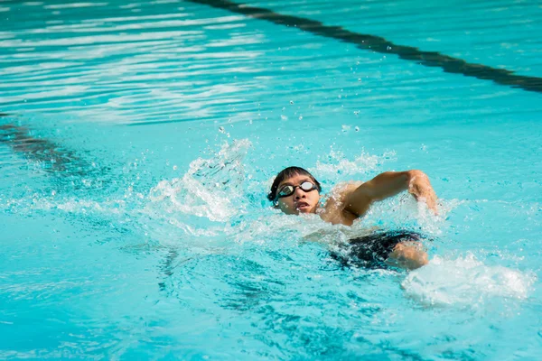 Junger Mann schwimmt im Rückenschwimmen in Pool. — Stockfoto