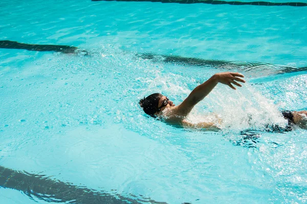 Junger Mann schwimmt im Rückenschwimmen in Pool. — Stockfoto