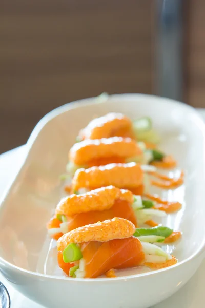 Salmon wrap with asparagus and topping with ebiko. Stock Photo