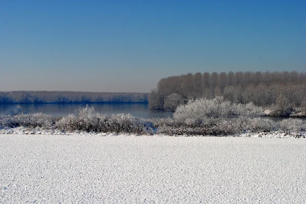 Ackerland und ein schneebedeckter Fluss — Stockfoto