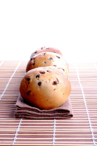 Sweet bread with chocolate drops over bamboo placemat — Stock Photo, Image