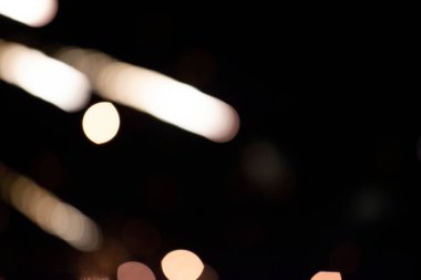 Siyah bir arka planda, altın bulanık çizgiler ve bokeh noktalar. Neşeli koyu arkaplan.