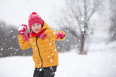 Kışın çocuk. Çocuk sokakta kartopu oynuyor..