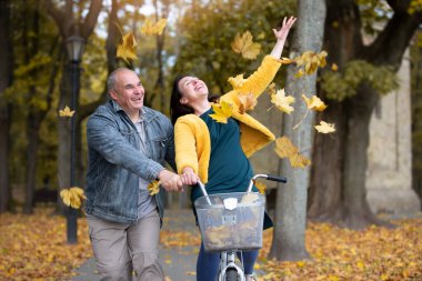 Autumn Park 'ta bisikletli mutlu orta yaşlı bir çift. Yaşlı, neşeli karı koca yürüyüşe çıkmış..