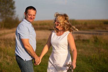 Doğanın arka planında birbirine aşık orta yaşlı güzel bir çift..