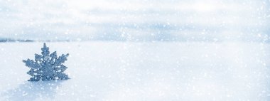 Noel arkaplanı. Kar taneli oyuncak kar yığınında.