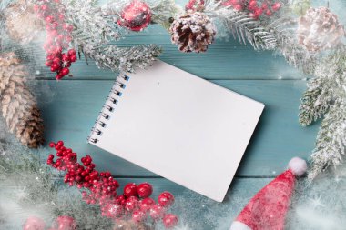 Turkuaz ahşap arka planda, ladin dalından dekorasyon, dizüstü bilgisayardan koni. Noel arkaplanı.