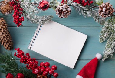 Turkuaz ahşap arka planda, ladin dalından dekorasyon, dizüstü bilgisayardan koni. Noel arkaplanı.