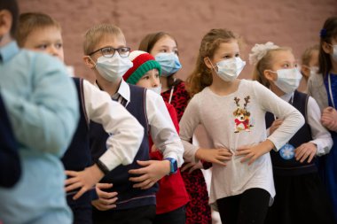 24 Aralık 2020. Belarus, Gomil şehri. Coronavirüs salgını sırasında şehirde Noel tatili. Coronavirus salgını sırasında Noel tatilinde maskeli çocuklar.