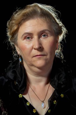 Siyah arka planda ince dudakları olan yaşlı bir kadının portresi..