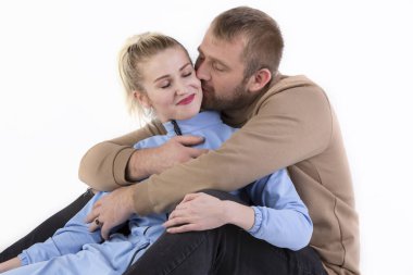 Beyaz arka planda, bir erkek bir kadını nazikçe öper. Karı koca..