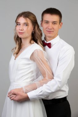 Gri arka planda gelin ve damadın klasik dikey portresi..