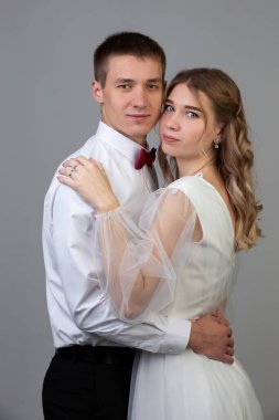 Gri arka planda gelin ve damadın klasik dikey portresi..