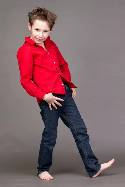 Όμορφο Αγόρι Κόκκινο Πουκάμισο Και Τζιν Γκρι Φόντο Ένα Παιδί — Φωτογραφία Αρχείου