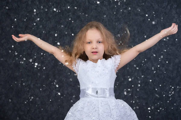 Красива Маленька Дівчинка Білій Сукні Піднятими Руками Під Літаючими Сніжинками — стокове фото
